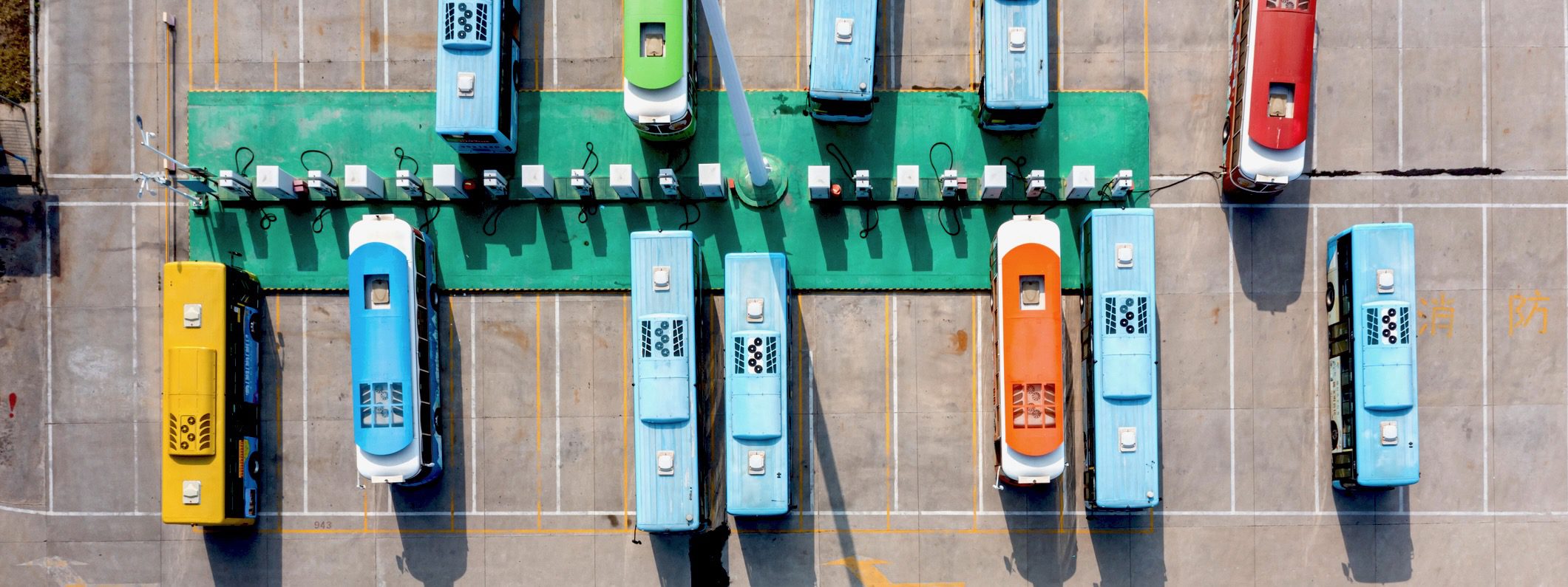 Buses charging at bus terminal Row of buses parked at the bus terminal, high angle top view