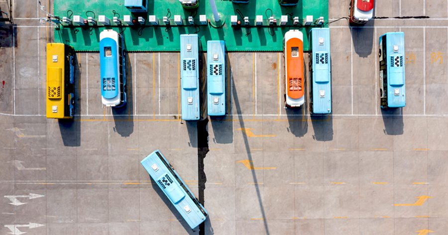 Buses charging at bus terminal Row of buses parked at the bus terminal, high angle top view