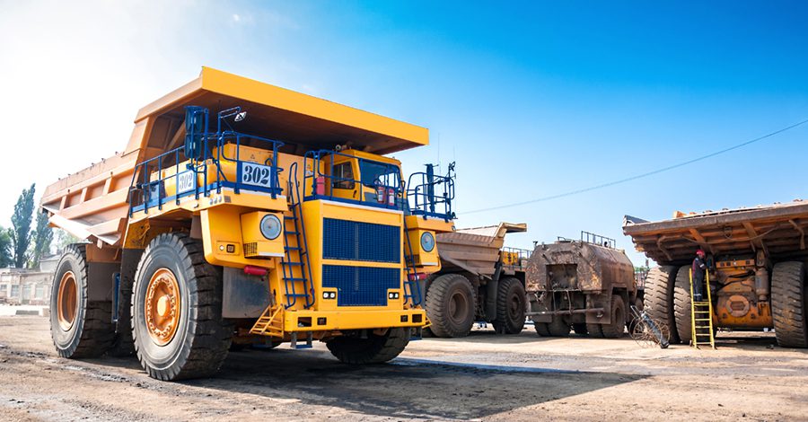 heavy open cast mine truck Quarry yellow dump truck drives alone industrial area at sunny day